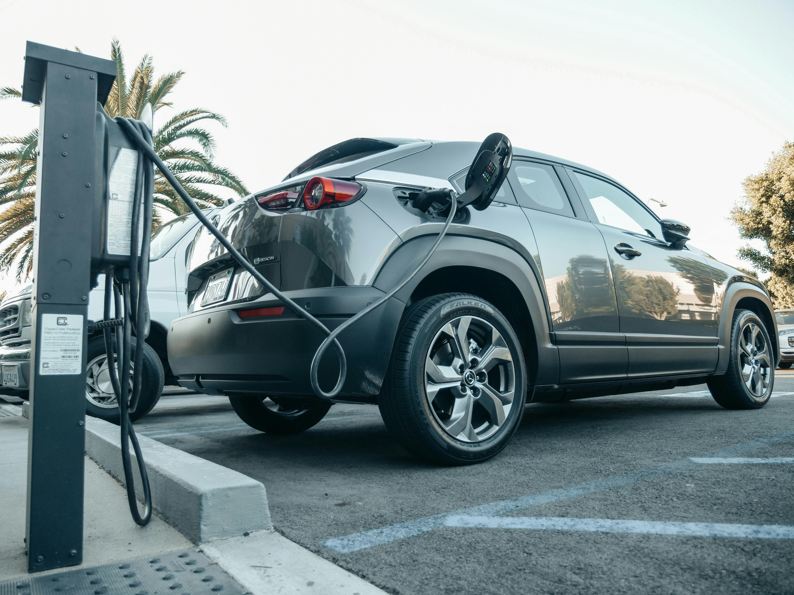 Electric vehicle charging at a public charging point, representing the benefits of fully funded EV charging installation for businesses and car parks